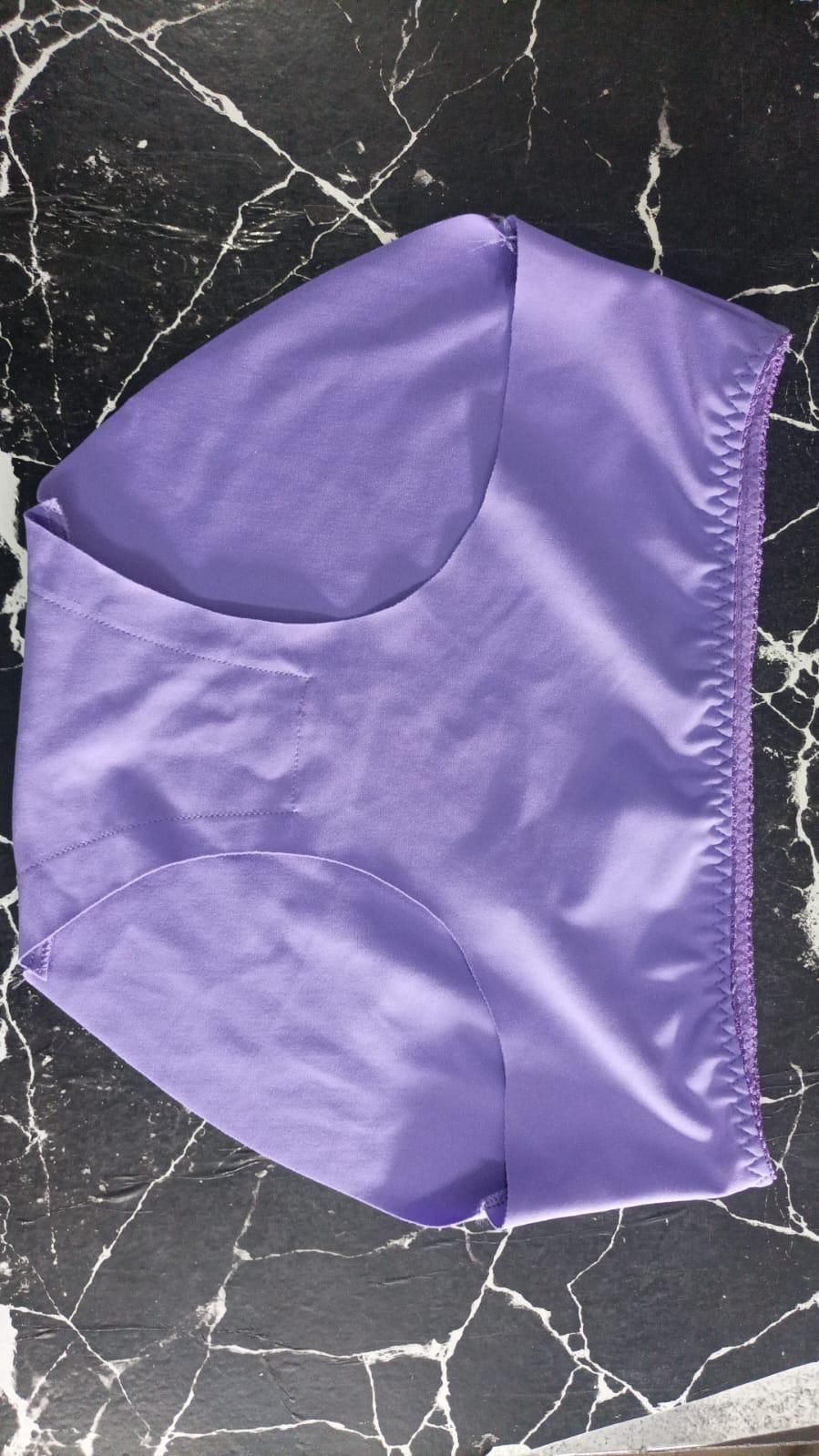 Purple seamless comfortable ladies' panties pack laid flat on black marble surface