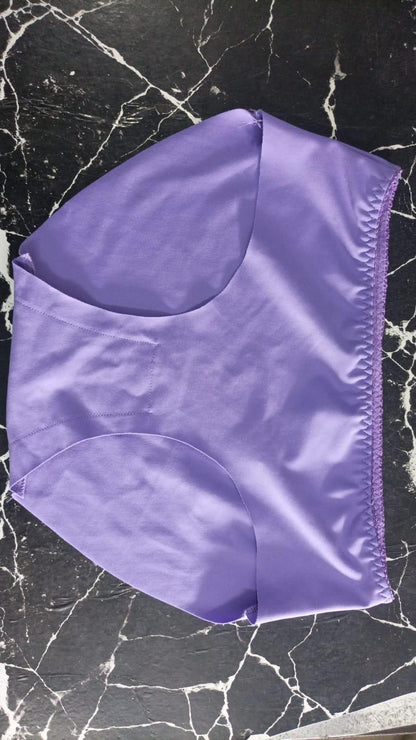 Purple seamless comfortable ladies' panties pack laid flat on black marble surface