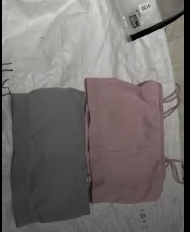 Gray and pink soft bralette for women laid flat on a surface showing stretchy fabric and thin straps